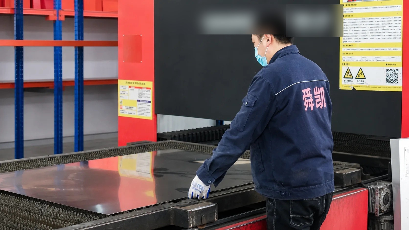 Checking a raw steel sheet on the laser cutting bed at SOKEI Fire factory