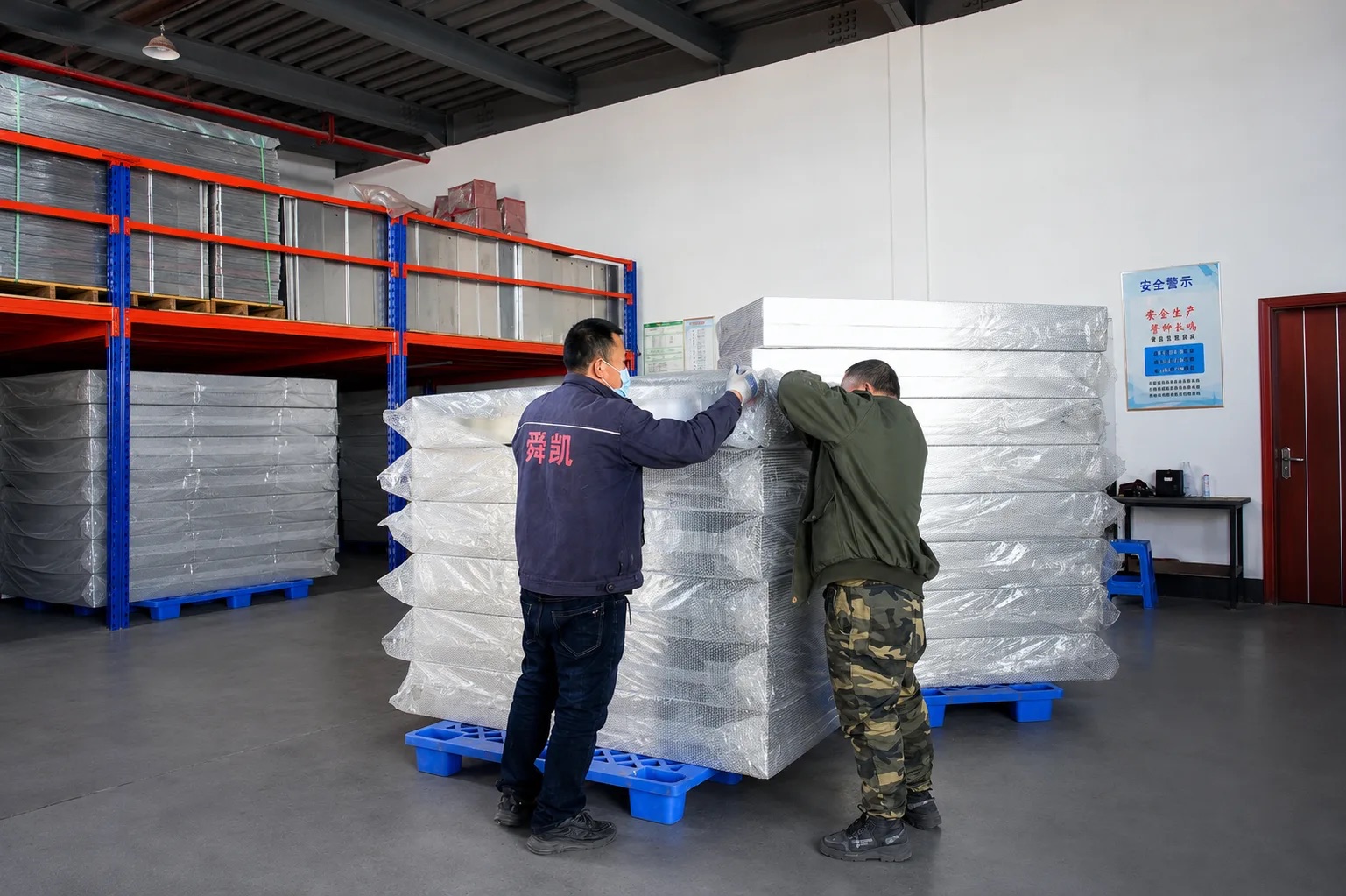Bubble-wrapped fire cabinet panels palletized for export container loading
